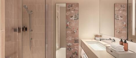 A modern bathroom with a glass-enclosed shower, a vanity with a sink, and decorative wall tiles.