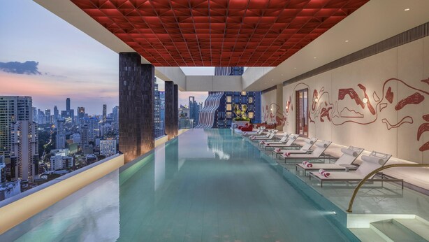 A modern rooftop infinity pool with lounge chairs and a cityscape view. - KROMO Bangkok, Curio Collection by Hilton (Bangkok)