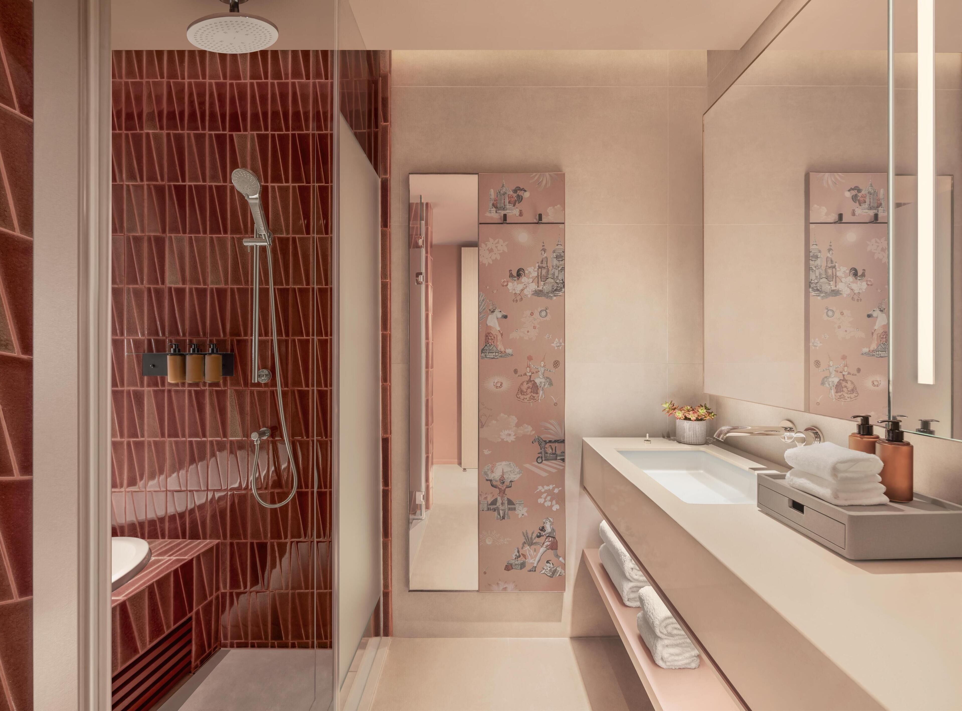 Un baño moderno con ducha a ras de suelo, tocador con un espejo grande y azulejos decorativos.