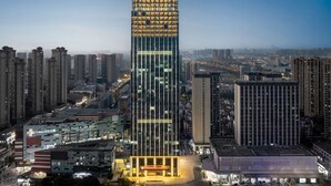 A high-rise hotel with a modern glass facade, multiple floors, and a prominent entrance with illuminated signage. - Hilton Garden Inn Hefei Feixi (Hefei)