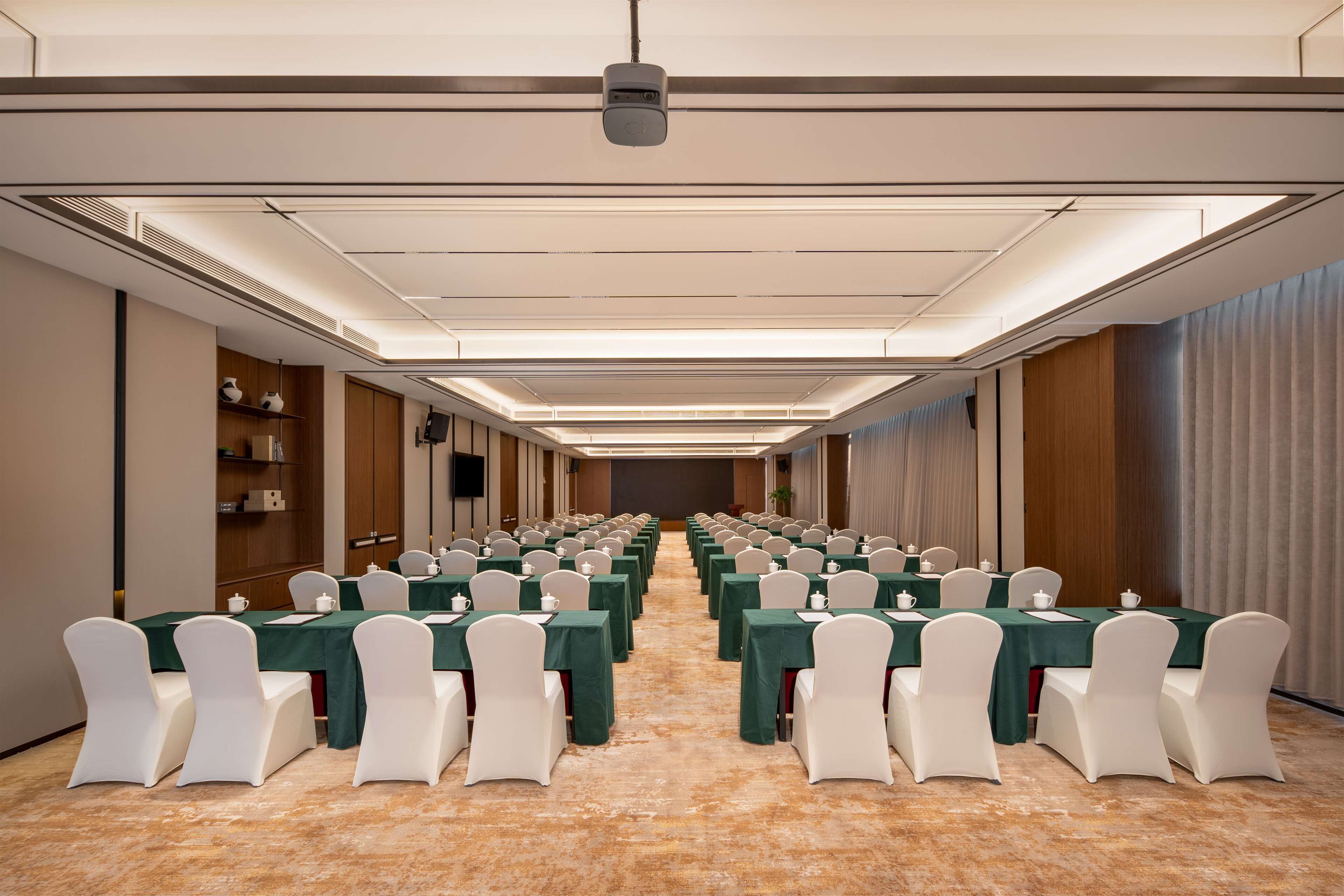 A conference room with rows of tables and chairs, equipped with nameplates and water bottles.