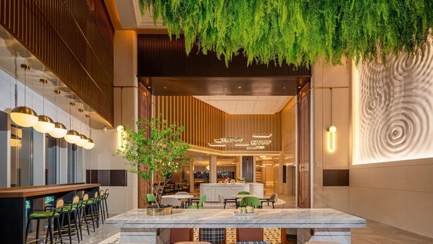 A modern hotel lobby with a bar area, seating, and a decorative wall. - Hilton Garden Inn Hefei Feixi (Hefei)