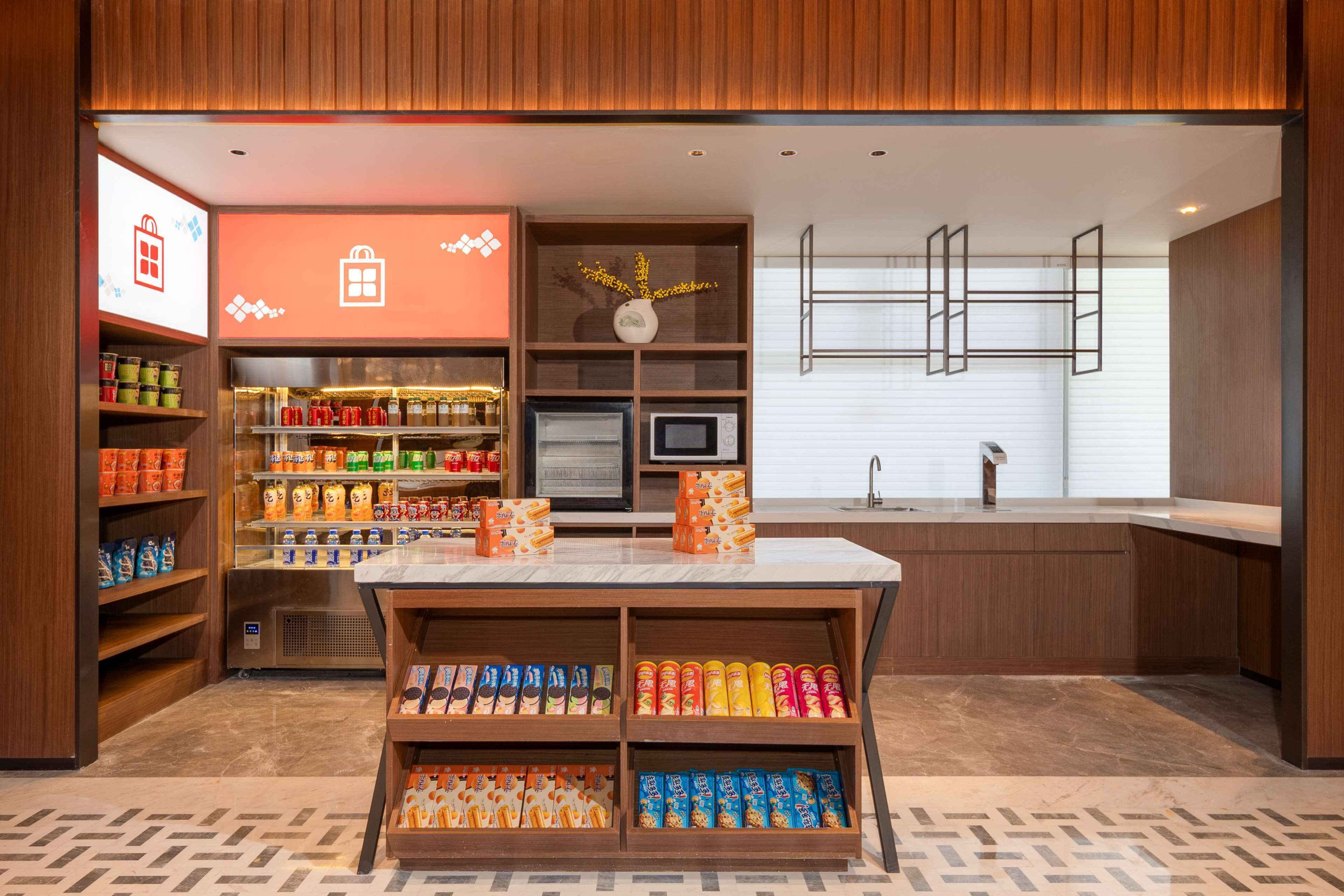 A modern, well-lit store with shelves stocked with snacks and beverages.