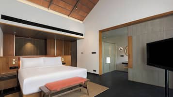 Una habitación de hotel moderna con una cama grande, un televisor de pantalla plana y techo de madera.