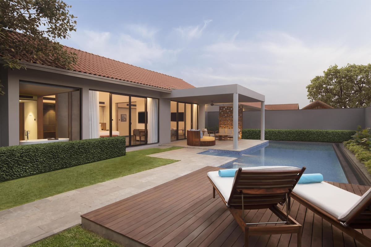 Une maison moderne dotée d’une piscine, d’une terrasse en bois et d’un patio couvert.