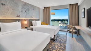 A hotel room with two beds, a large mural, a view of the city, and a balcony with seating. - Hilton Garden Inn Jabalpur (Jabalpur)