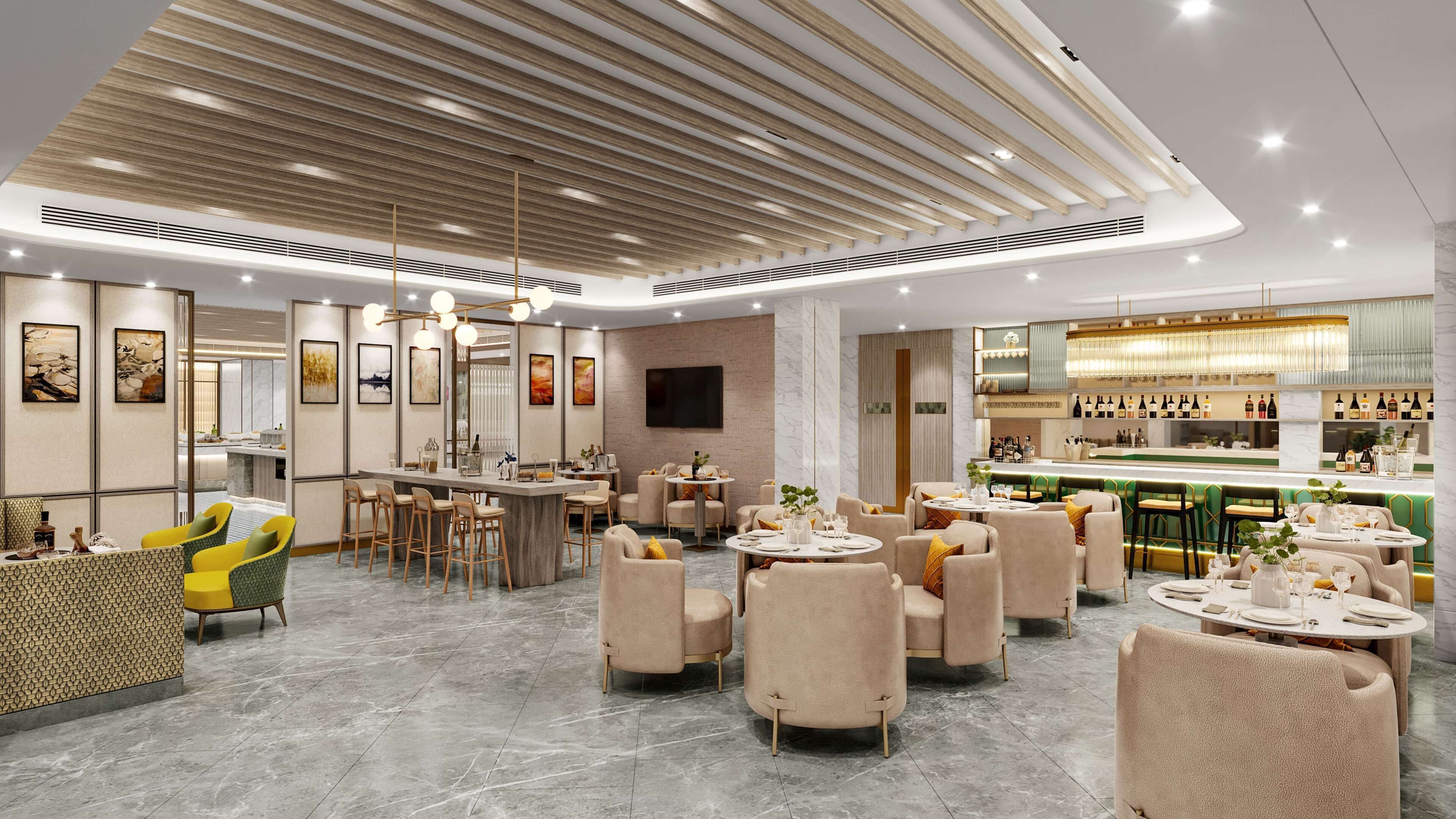 A modern hotel lobby with a bar area, seating arrangements, and artwork on the walls.