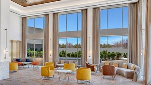 A spacious lobby with large windows, a variety of seating options, and a modern ceiling design. - Hilton Garden Inn Jabalpur (Jabalpur)