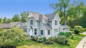 A two-story house with a gabled roof, a front porch, and a well-maintained garden.