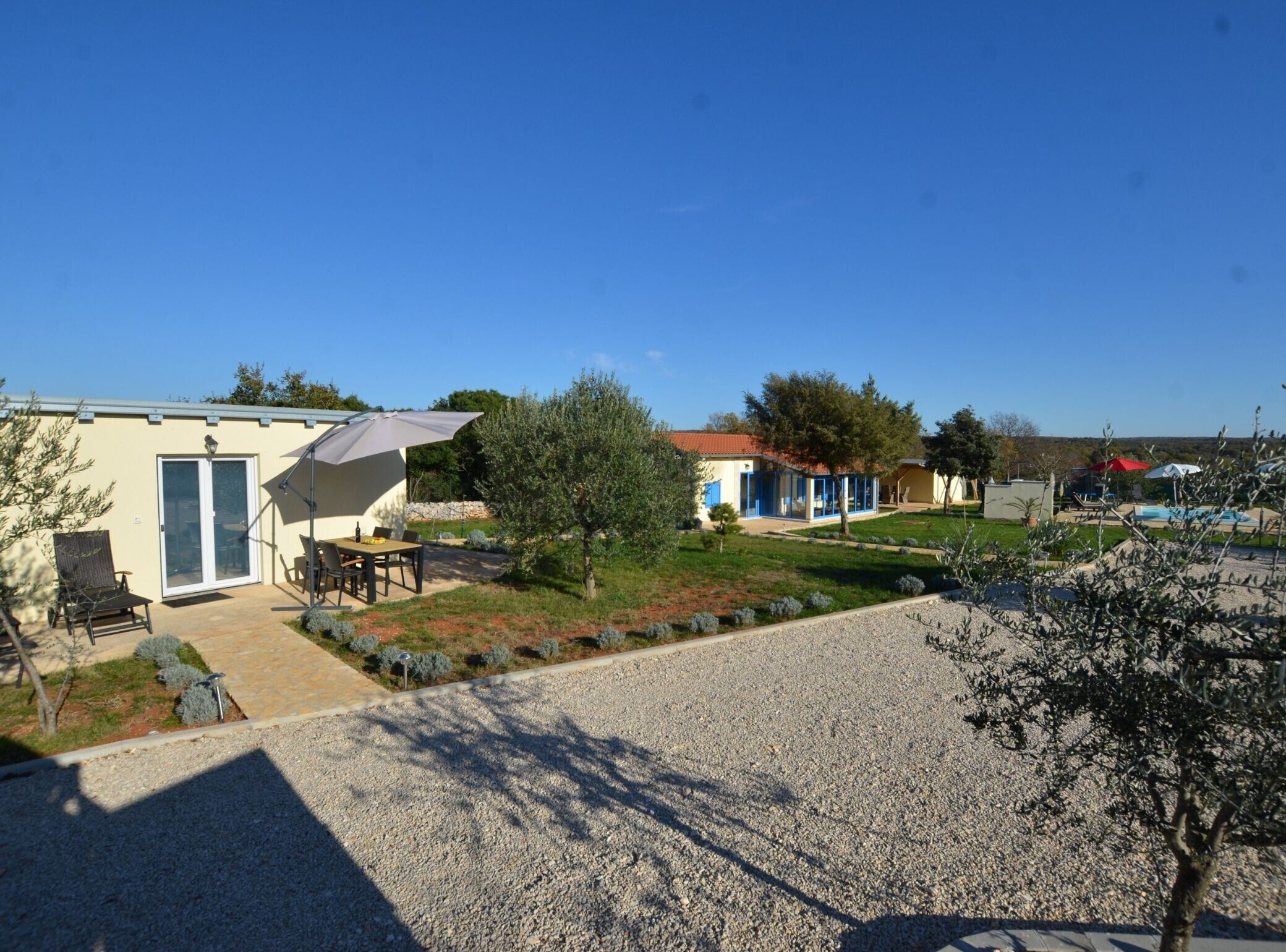 A residential area with a house featuring a patio with outdoor furniture and a covered table.