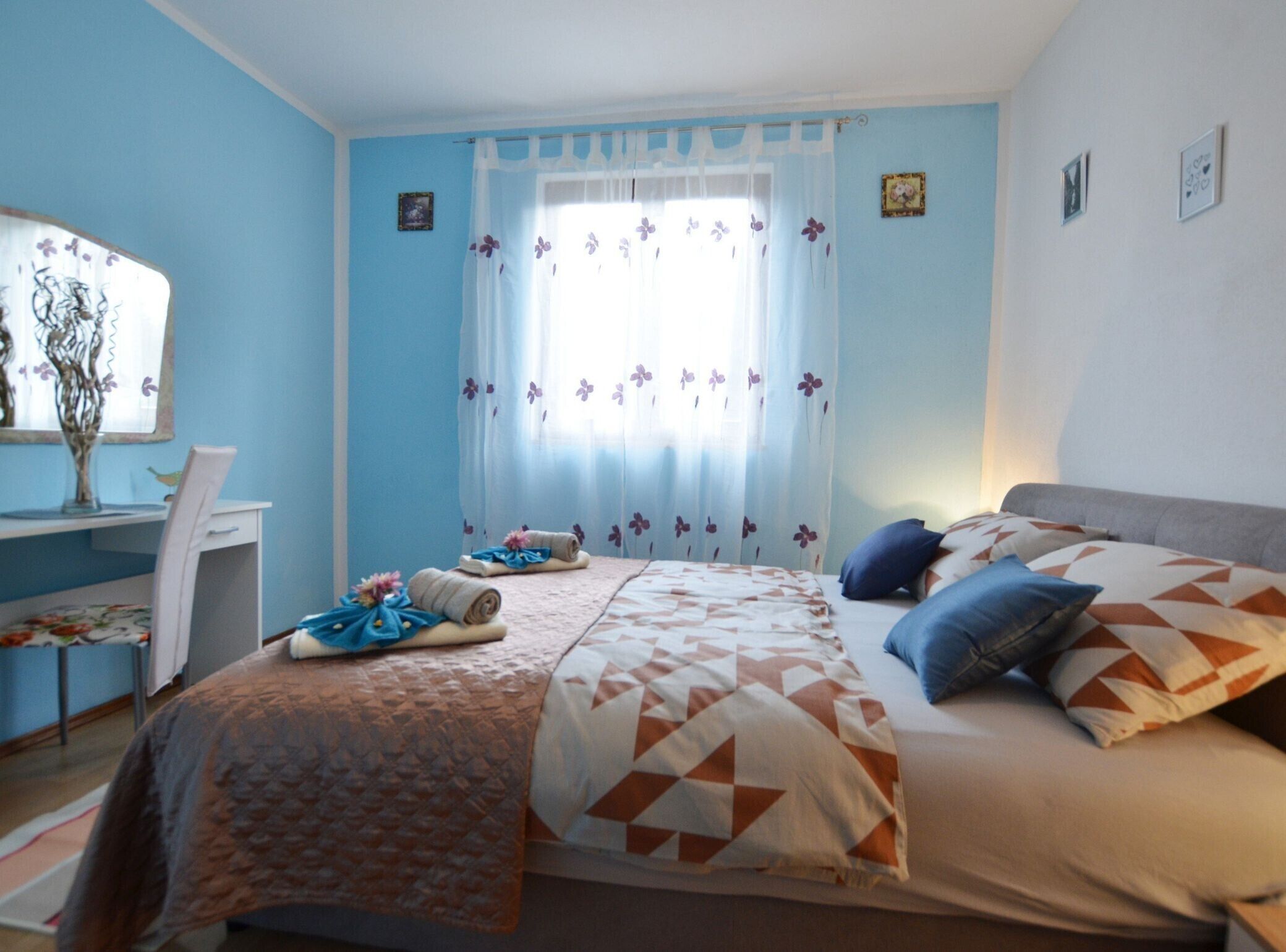 A bedroom with a bed, a desk, and a chair.