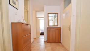 Ein Flur mit Holzschränken, einem Spiegel und einer Tür zum Schlafzimmer.