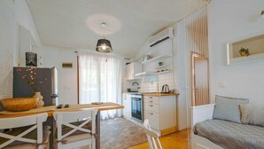 A compact kitchen with a dining area, a sofa, and a hanging light fixture. - Snug and Stylish Downtown Rovinj Apartment - One Bedroom Apartment with Balcony (Rovinj)