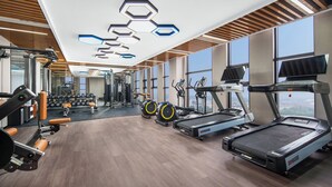 Ein modernes Fitnessstudio mit Laufbändern, Crosstrainern und Krafttrainingsgeräten.