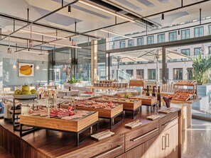 A buffet setup with various food items and a modern interior design.