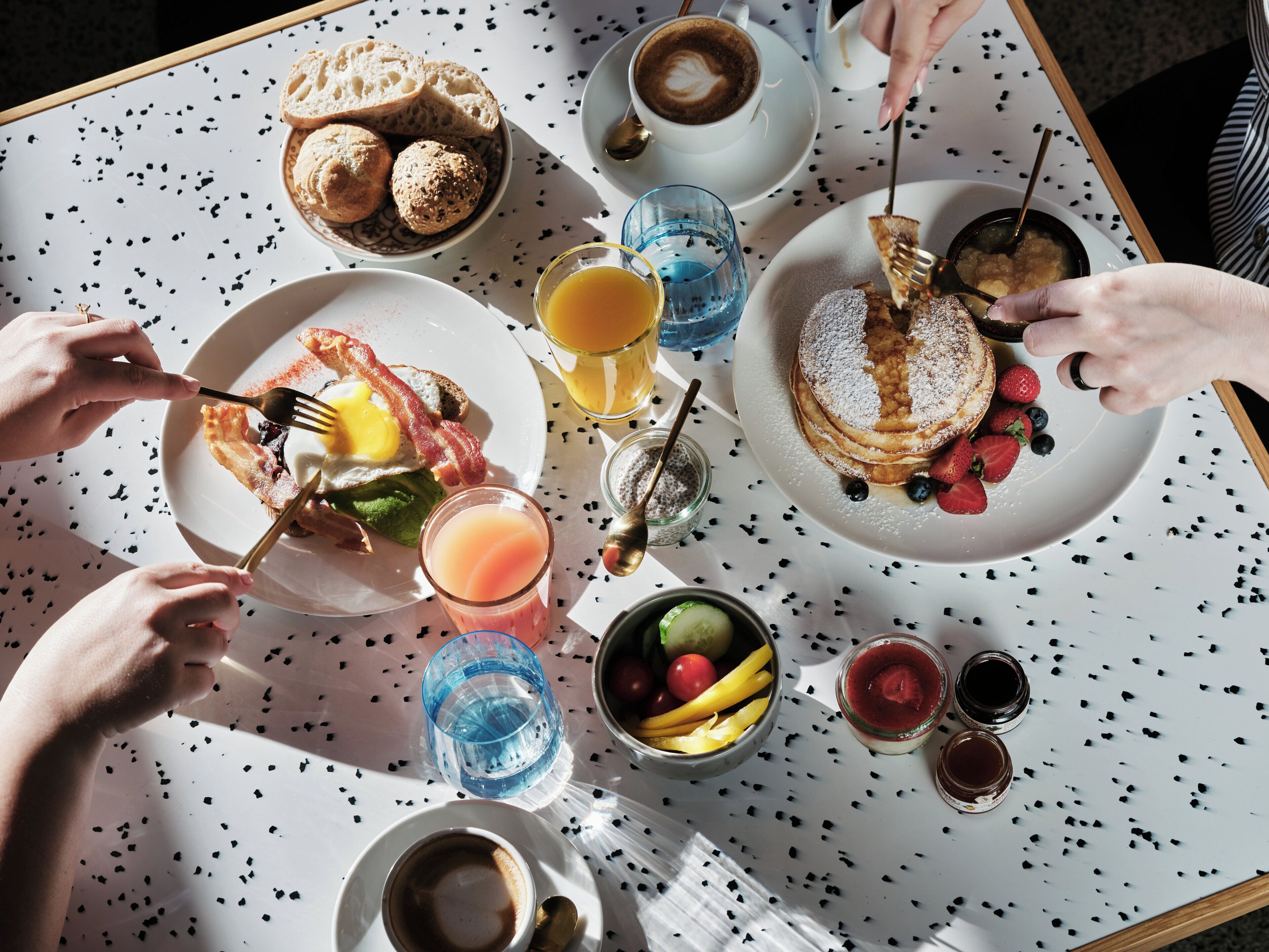 A breakfast setting with various food items and drinks on a table.