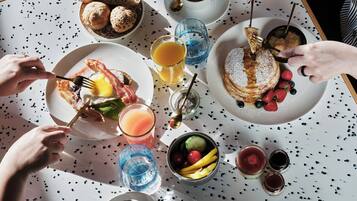 A breakfast setting with various food items and drinks on a table.