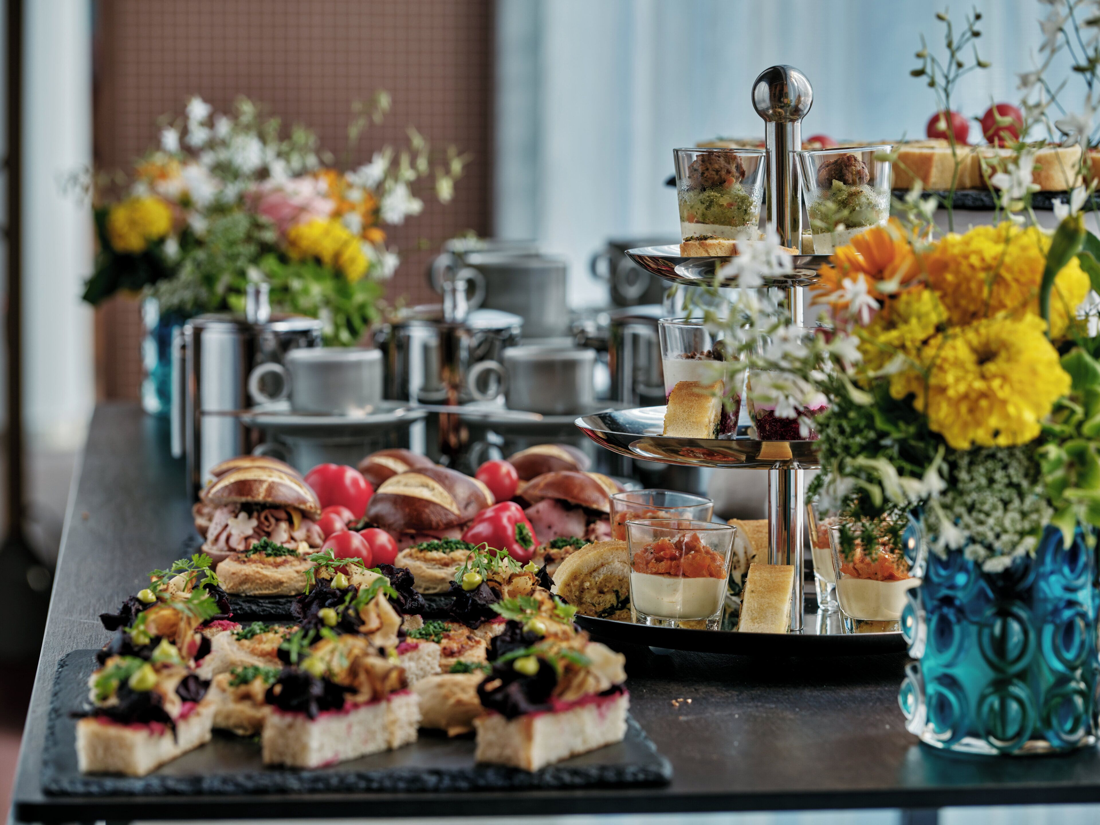 A buffet table with various food items and a tiered drink dispenser.