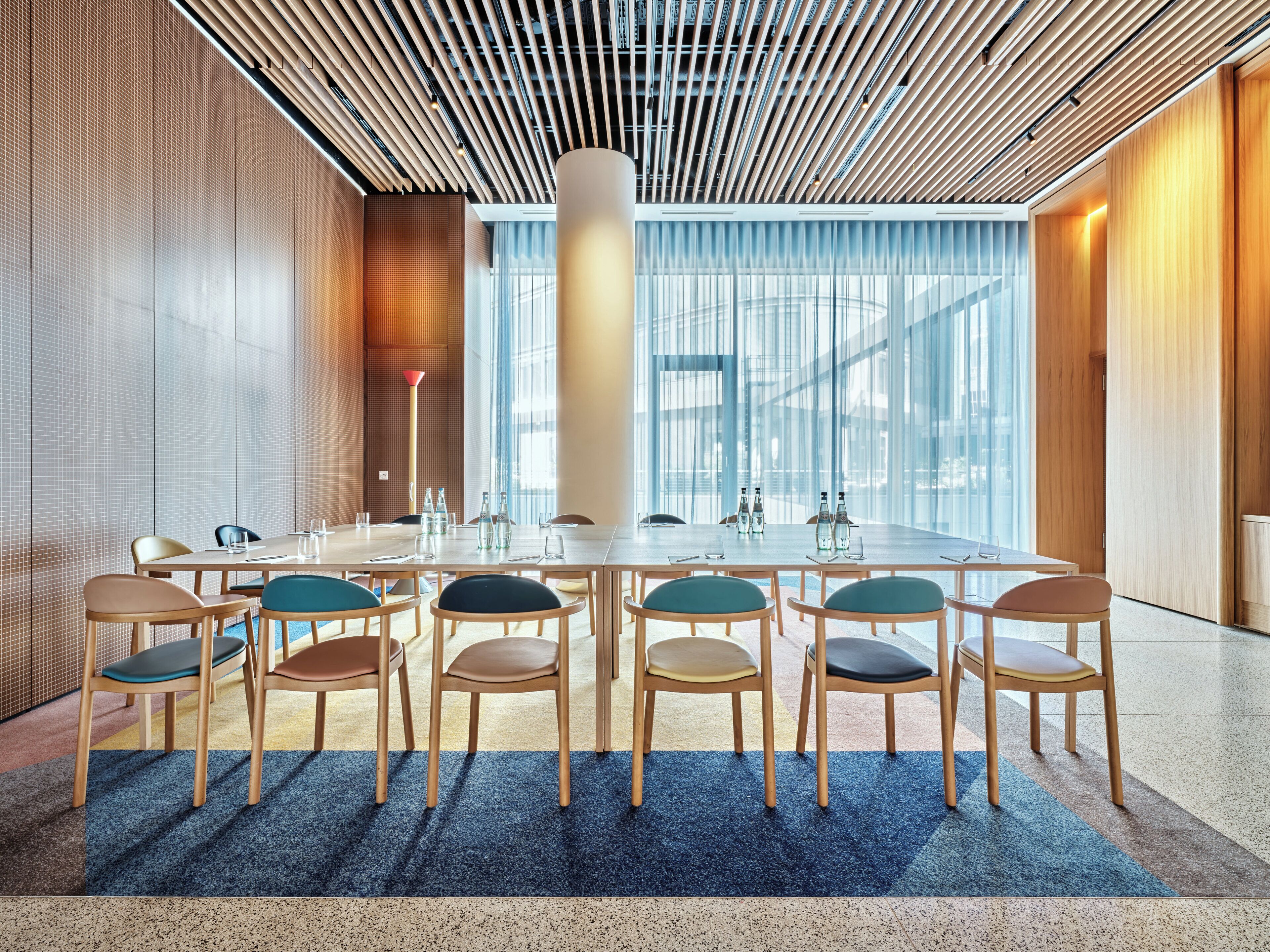 A conference room with a long table, chairs, and a large window.