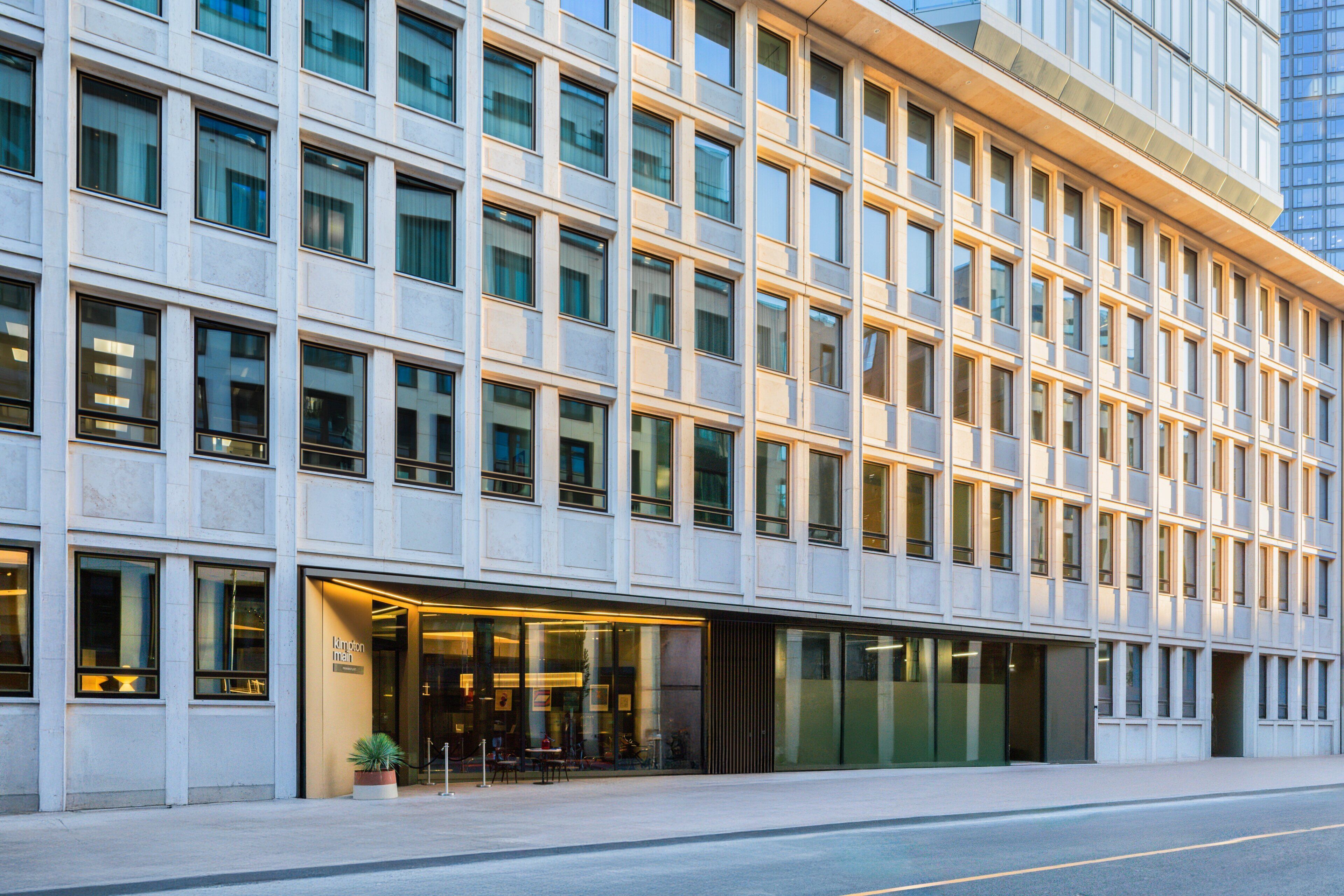 A modern building with a series of windows and a ground-level entrance with a glass facade.