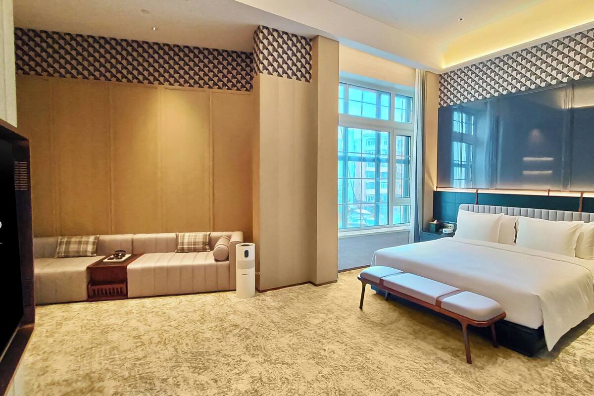 A spacious bedroom with a large bed, a sofa, and a small table.