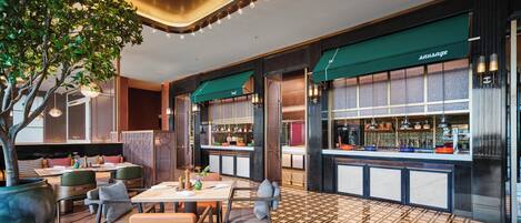 Un restaurante moderno con barra, suelo de madera y toldos verdes.
