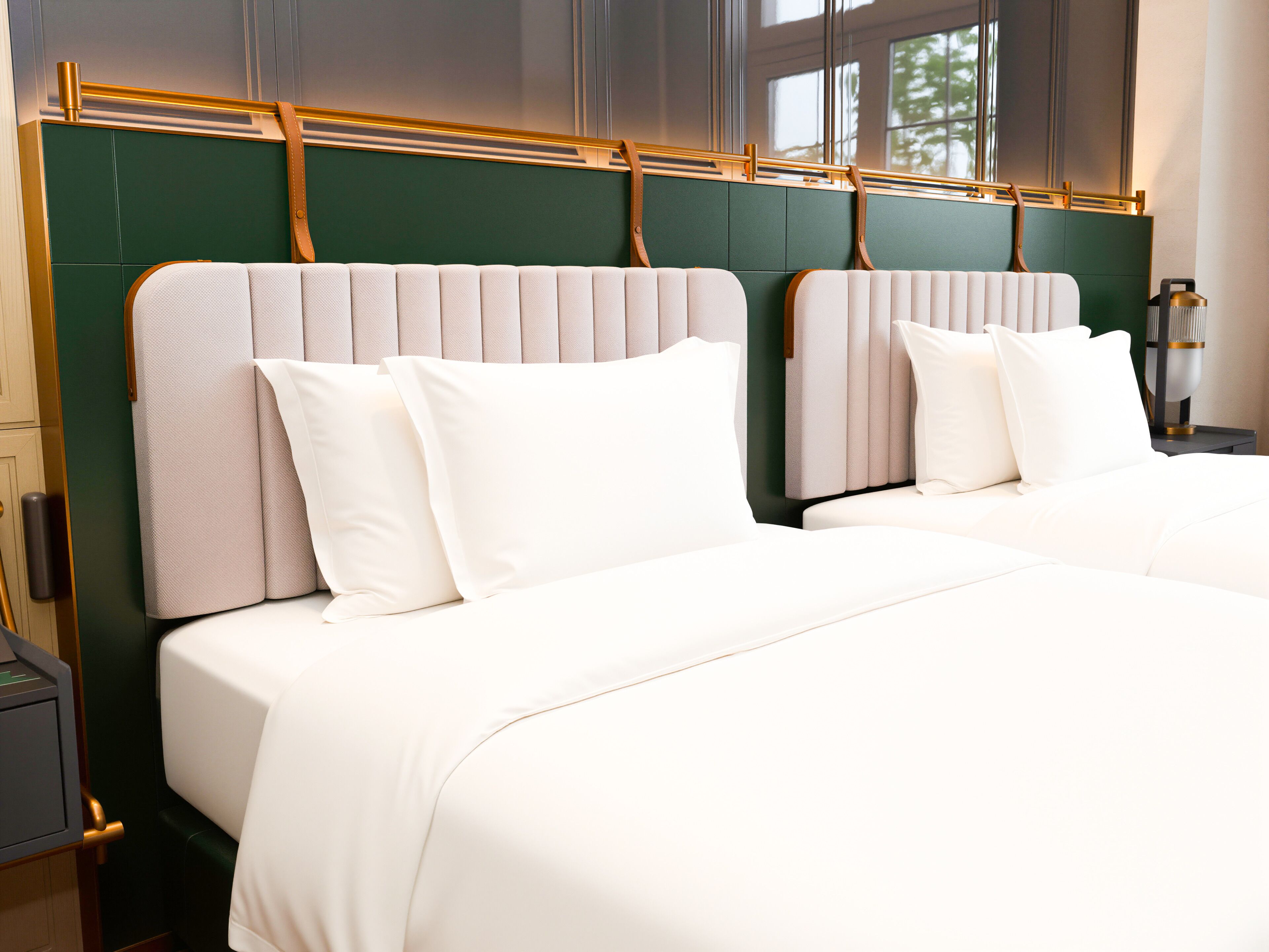 A hotel room with two beds, a green headboard, and a nightstand with a lamp.