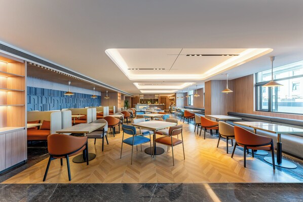 A modern restaurant with wooden paneling, herringbone flooring, and a variety of seating options including tables and booths. - Holiday Inn Express Luoyang Longmen by IHG (Luoyang)