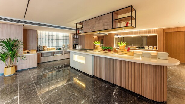A modern kitchen with a central island, built-in appliances, and a wooden finish. - Holiday Inn Express Luoyang Longmen by IHG (Luoyang)