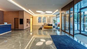 A modern lobby with a reception desk, seating area, and large windows offering views of the outside. - Holiday Inn Express Luoyang Longmen by IHG (Luoyang)