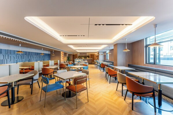 A modern restaurant with high tables and booths, wooden flooring, and pendant lighting. - Holiday Inn Express Luoyang Longmen by IHG (Luoyang)