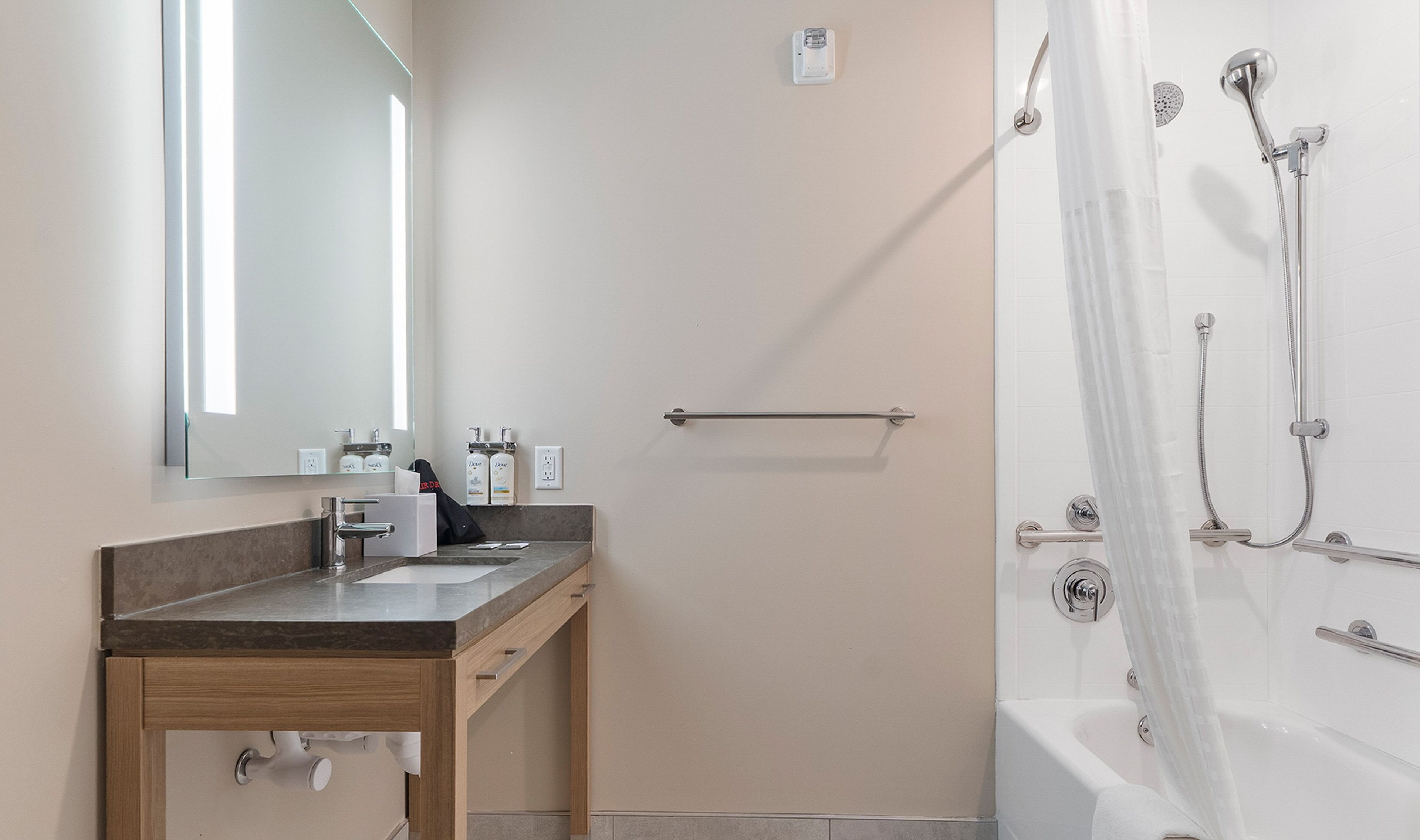 Une salle de bain moderne avec un meuble-lavabo, un miroir et un espace douche.