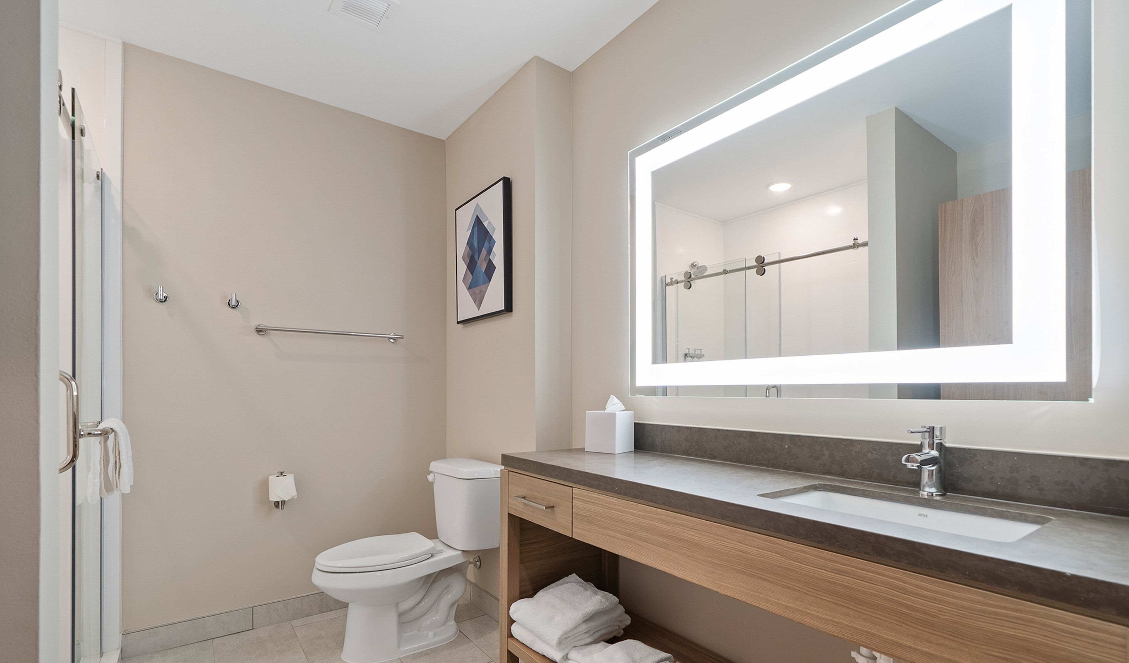 A modern bathroom with a toilet, sink, and shower.