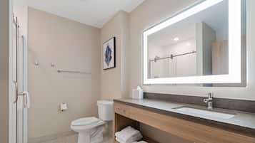 A modern bathroom with a toilet, sink, and shower.