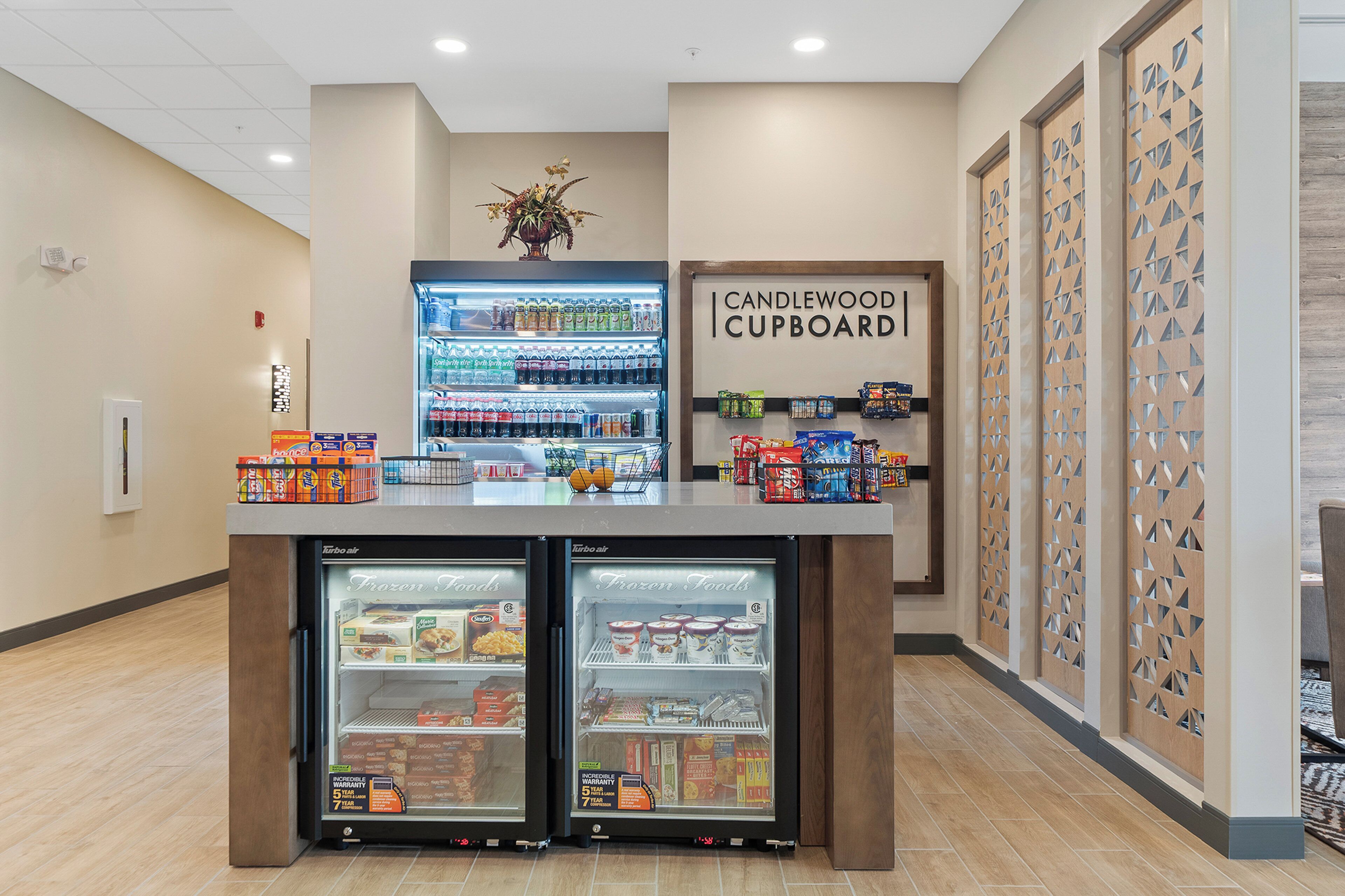 A self-service beverage station with refrigerated drink dispensers and a selection of snacks.