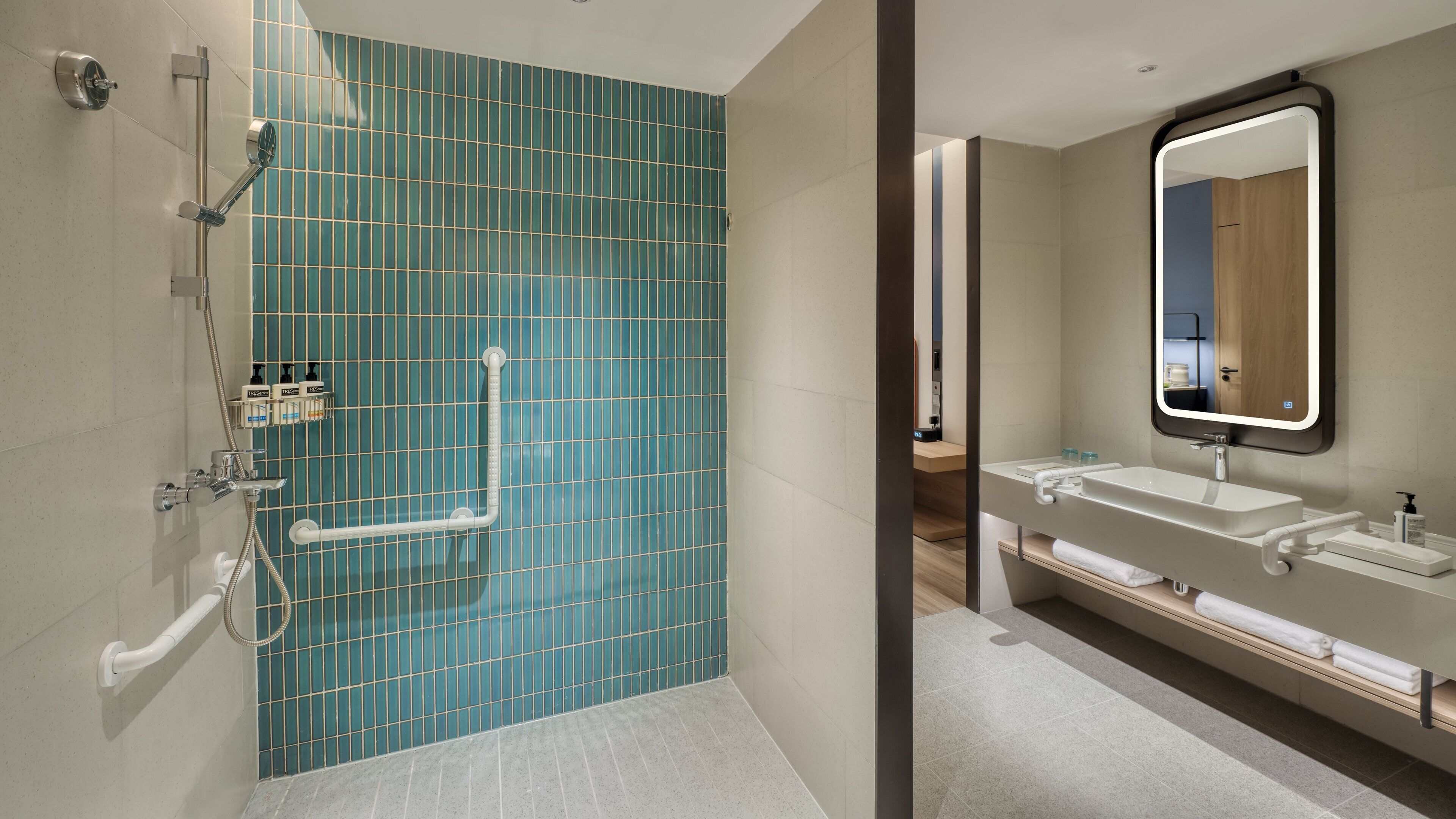 Une salle de bain moderne avec une douche, un lavabo et un miroir.