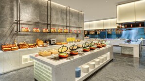 A modern breakfast buffet with various food items and a self-service beverage station. - Rugao City Center by IHG (Nantong)