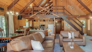 A spacious living area with leather sofas, a wooden coffee table, and a staircase leading to a loft. - Arnold Chalet Near Town & Calaveras Big Trees! (Arnold)