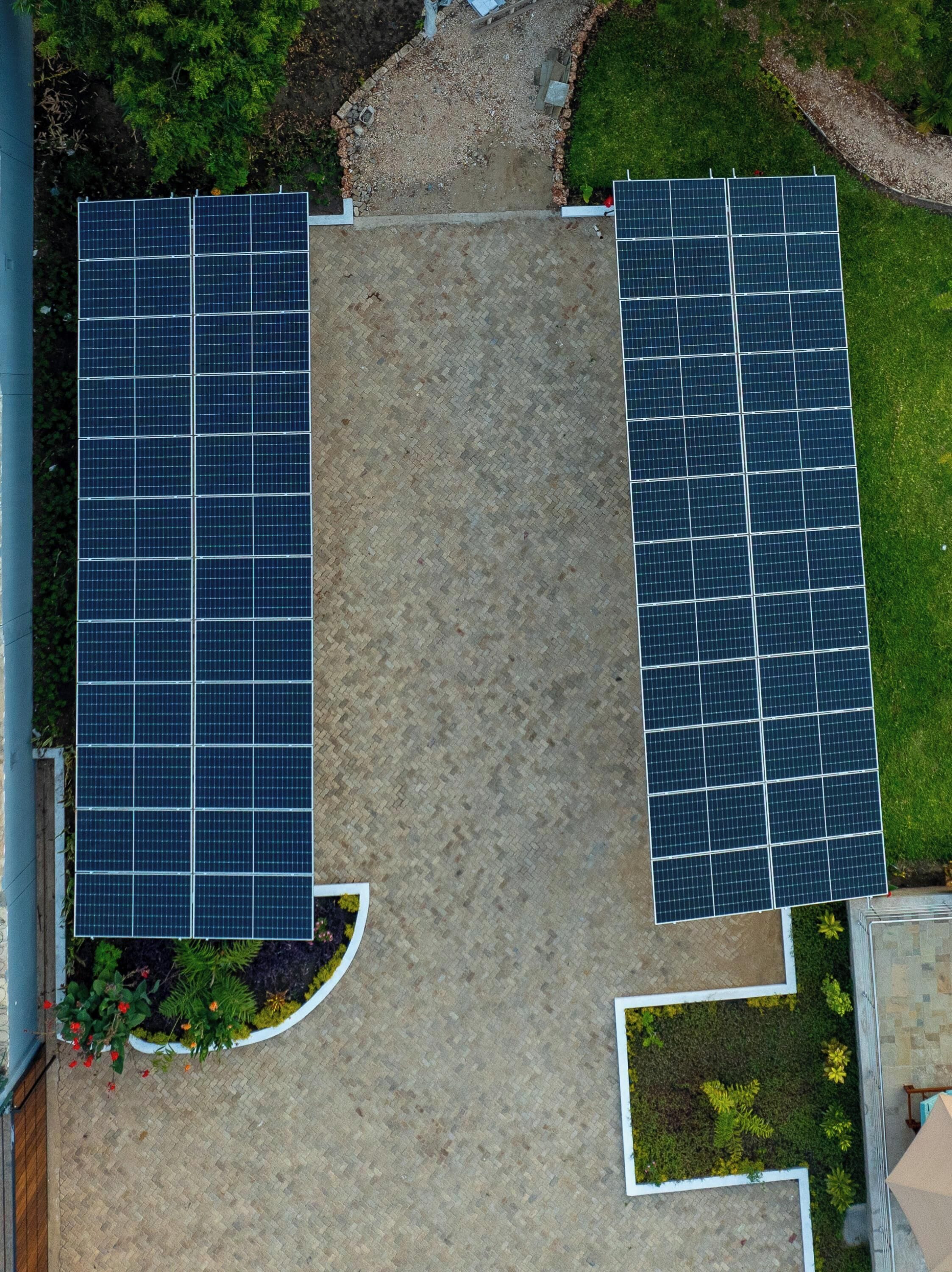A rooftop with two large solar panels and a paved walkway.