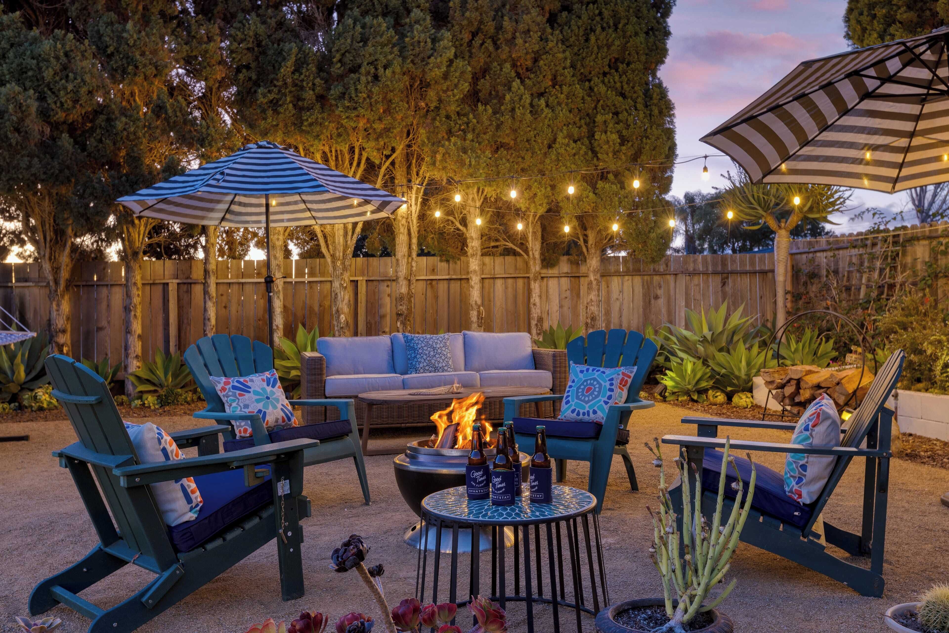 A patio area with outdoor furniture, a fire pit, and string lights.