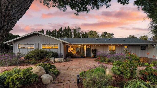 A two-story house with a stone pathway leading to the entrance, surrounded by various plants and trees. - Hummingbird Haven by Avantstay Dog-friendly, Near the Beach, Huge Yard+hot Tub (Santa Barbara)