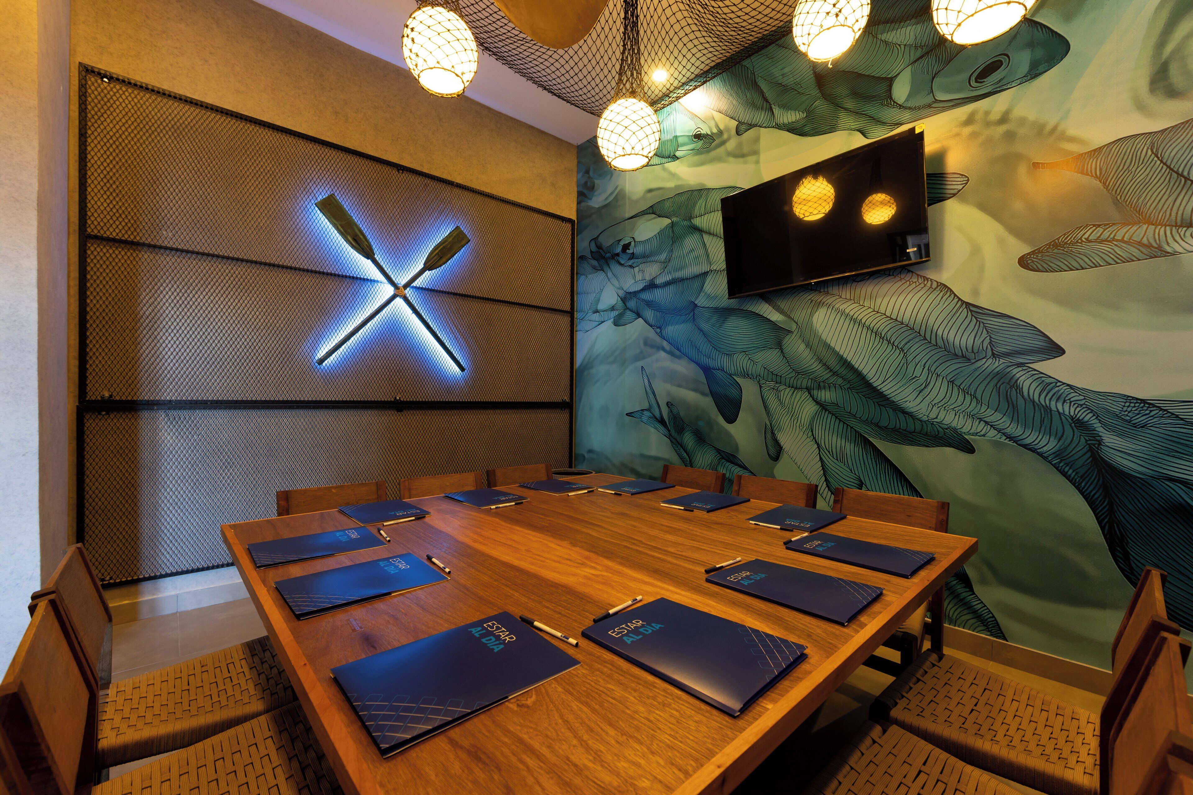 A conference room with a large wooden table, chairs, and a wall-mounted clock.