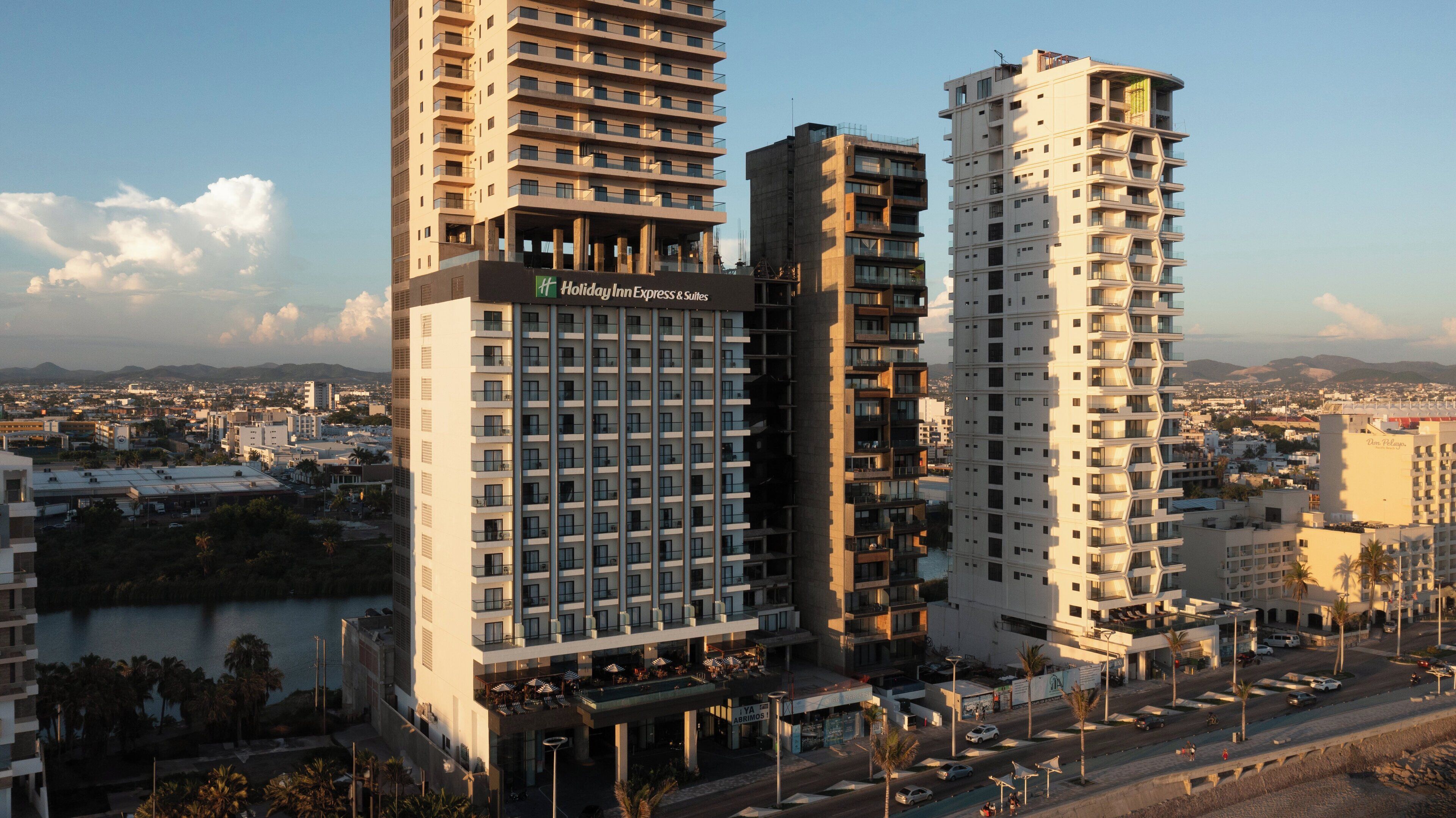 A hotel with multiple floors, balconies, and a view of the cityscape.