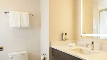 Ein modernes Badezimmer mit Toilette, Waschbecken und Spiegel.