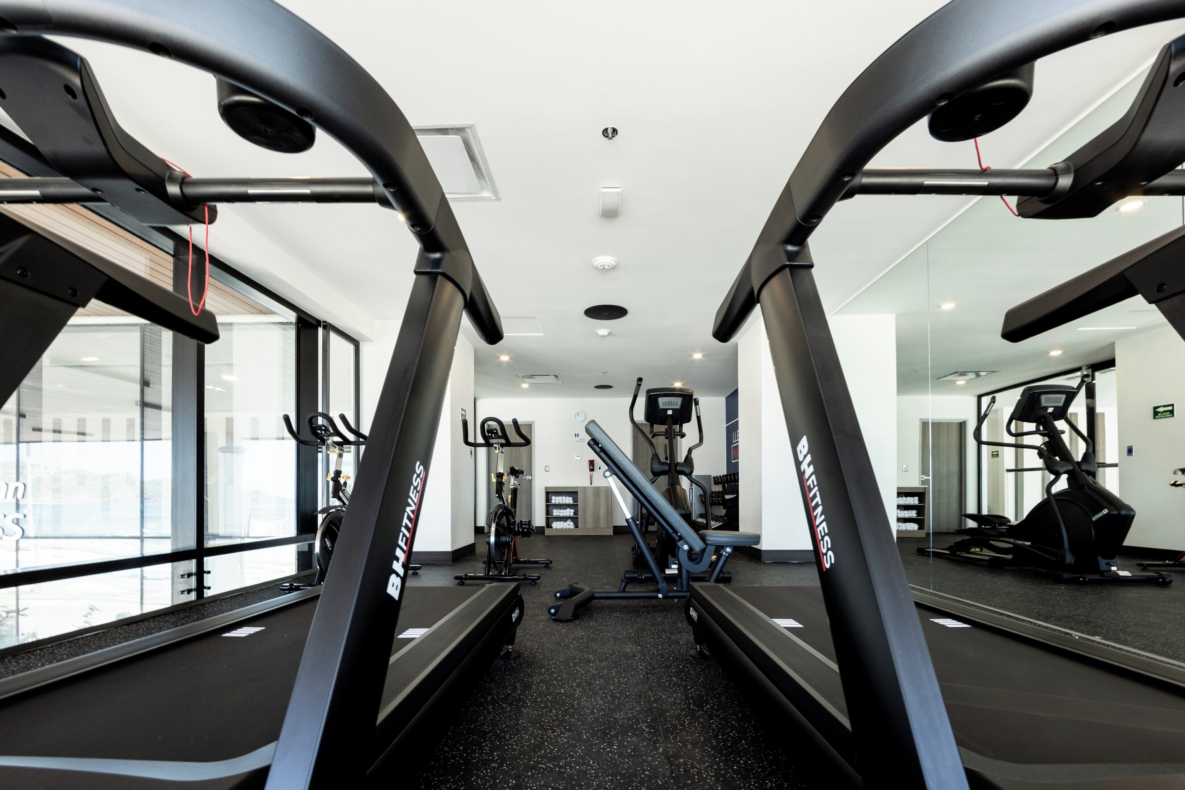 A gym with treadmills, exercise bikes, and weight machines.
