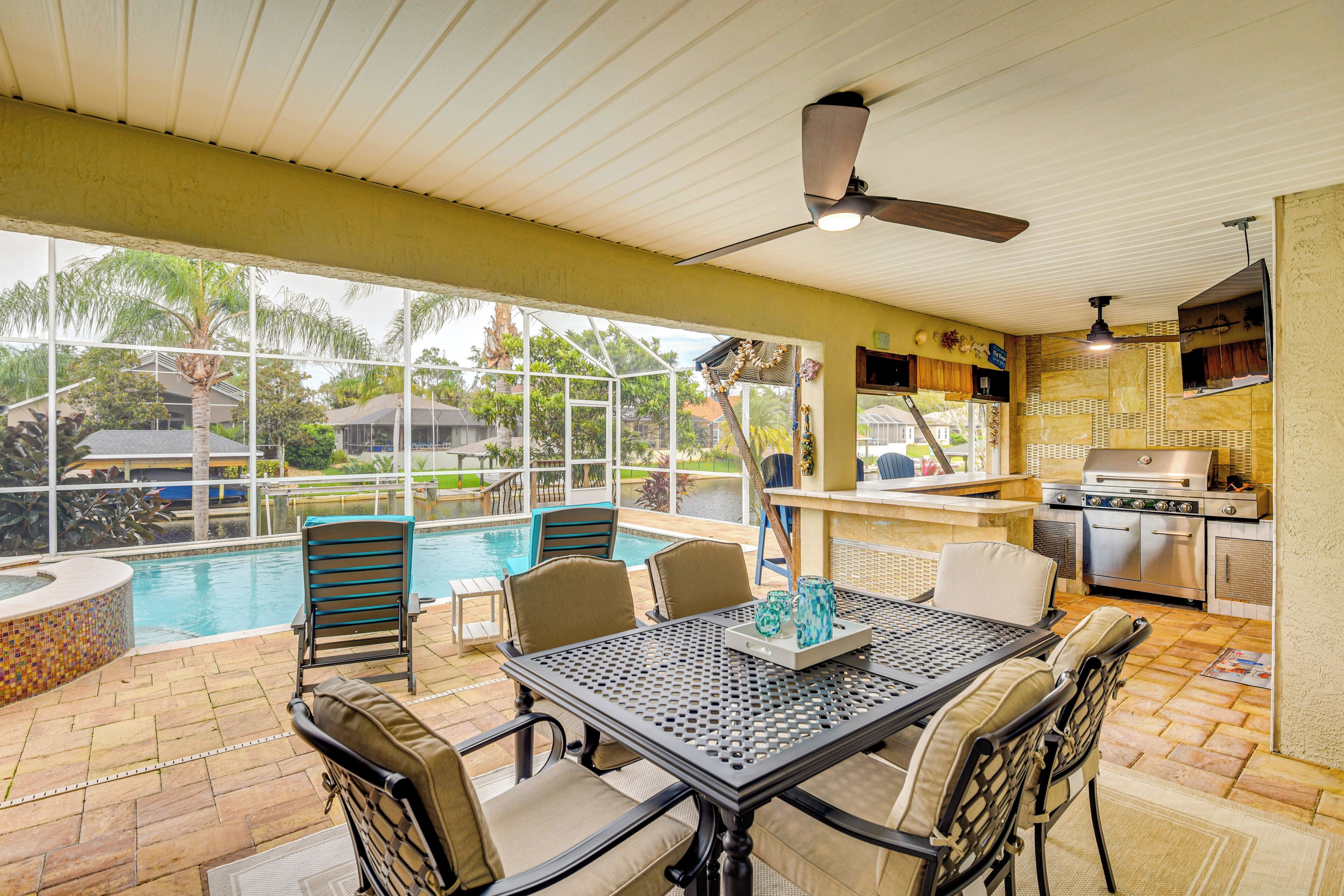 Une terrasse extérieure avec une piscine, des sièges et un espace barbecue.