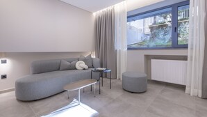 Una sala de estar moderna con un sofá gris, una mesita redonda y un banco.