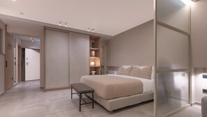 Un dormitorio moderno con una cama, un banco, un armario y una estantería.