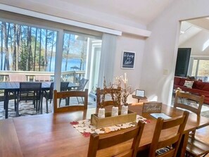 A dining area with a wooden table, chairs, and a view of the outdoors.