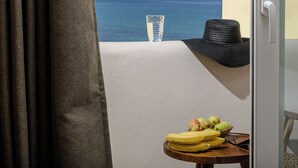 A balcony with a view of the sea, a glass of water, a hat, and a table with fruits and a pair of glasses. - Almi of Naxos (Naxos)